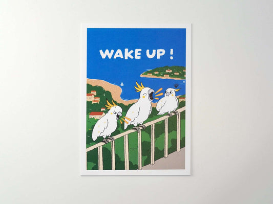 +61 Studio WAKE UP! A6 postcard by 9to5 Studios featuring three white cockatoos yelling on a railing with Sydney Harbour Bridge background