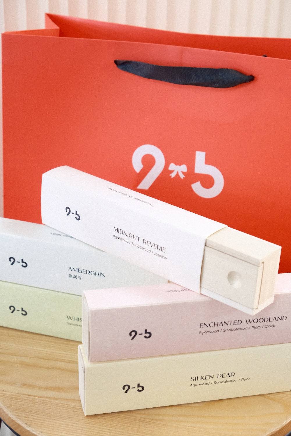 Pastel incense boxes including Enchanted Woodland on wooden table with orange shopping bag