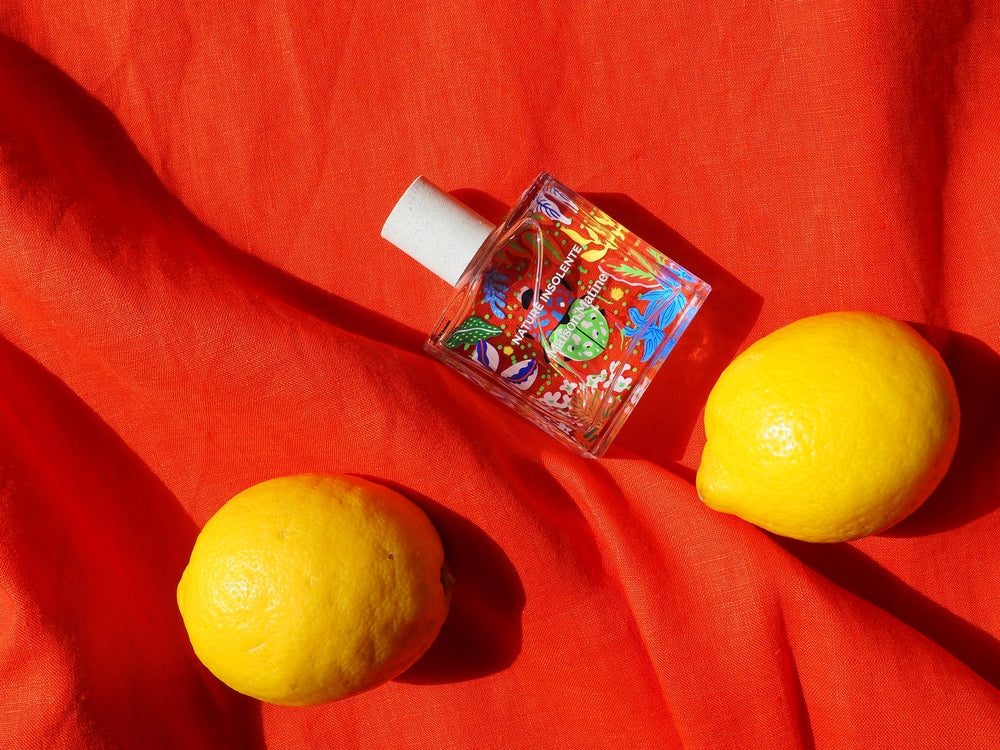 Maison Matine Nature Insolente perfume bottle with lemons on red fabric