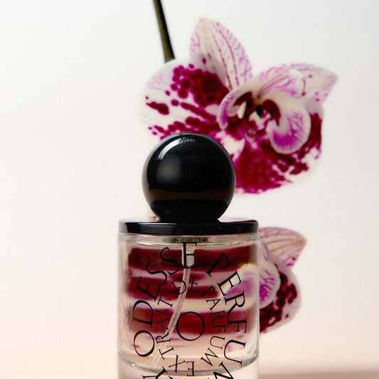 Odesse Deep Orchid bottle against magenta speckled orchid bloom at 9to5 Studios