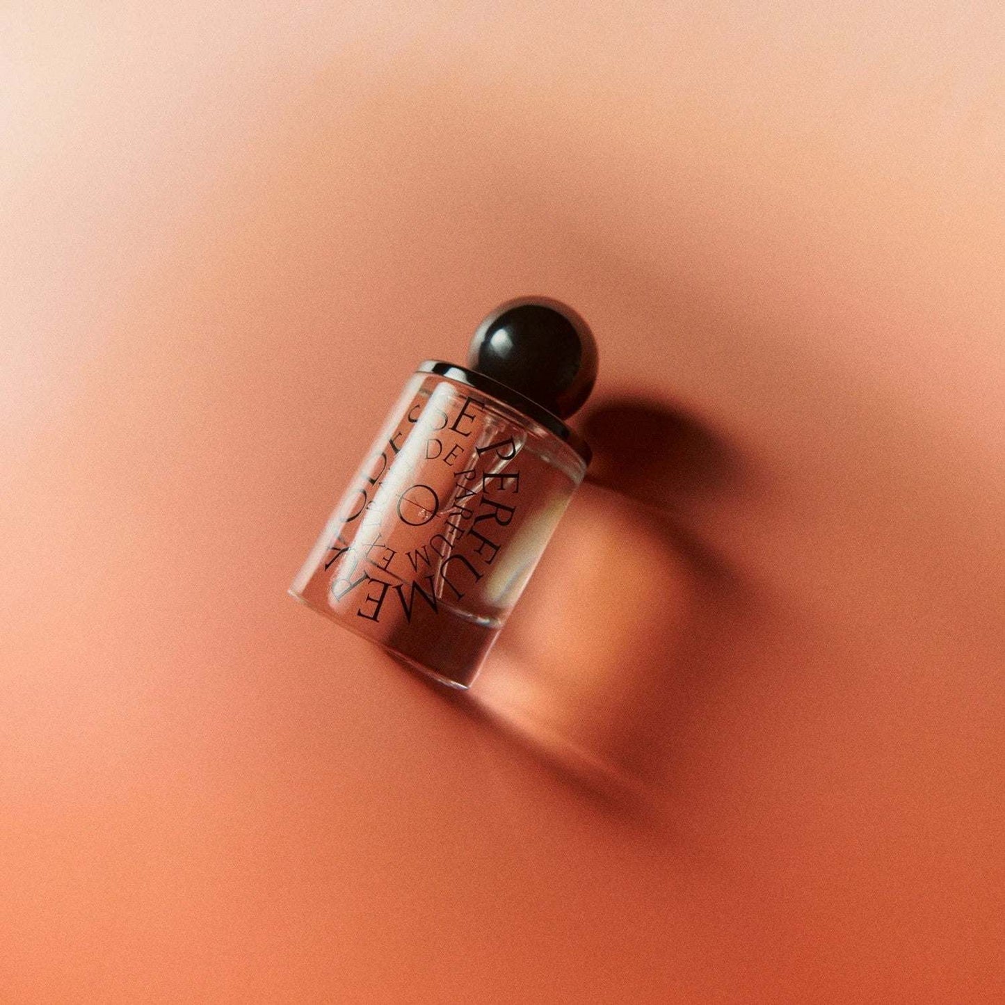 Odesse The Valley perfume bottle lying on coral-pink background at 9to5 Studios