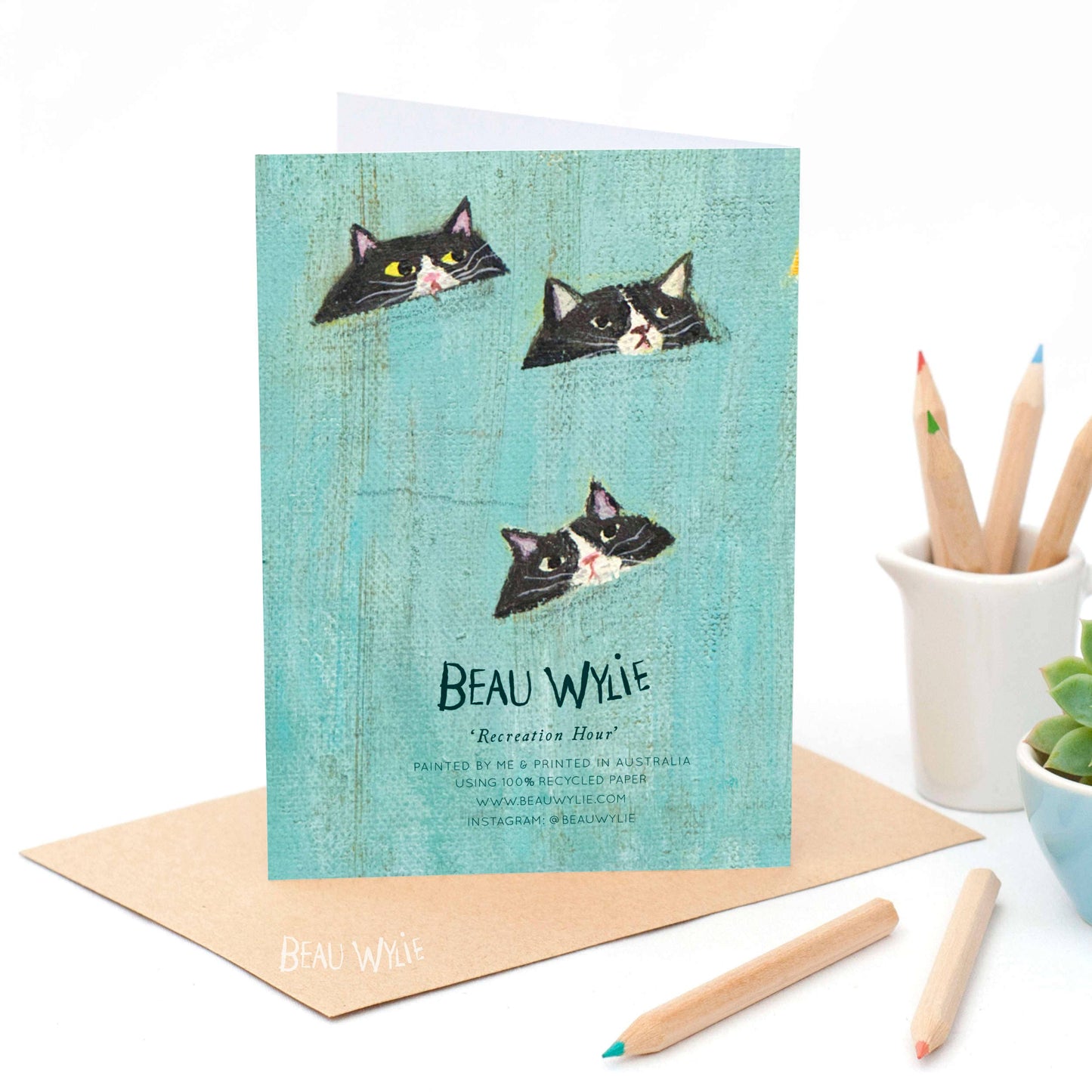 Recreation Hour cat art greeting card by Beau Wylie printed on teal recycled paper with wood grain texture and black-and-white feline faces