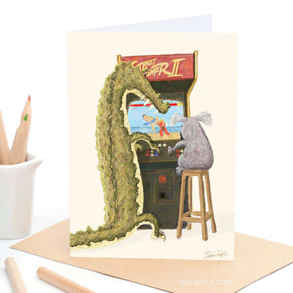 Street Fight greeting card by Beau Wylie for 9to5 Studios featuring green crocodile and koala on arcade cabinet, A6 recycled white cardstock