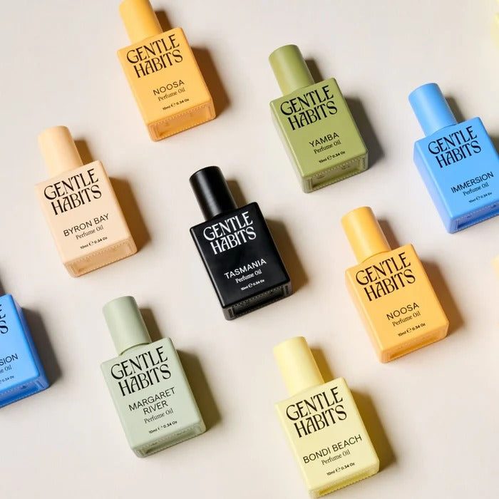 Gentle Habits Perfume Oil collection flat lay with eight pastel and earthy scents in square glass bottles