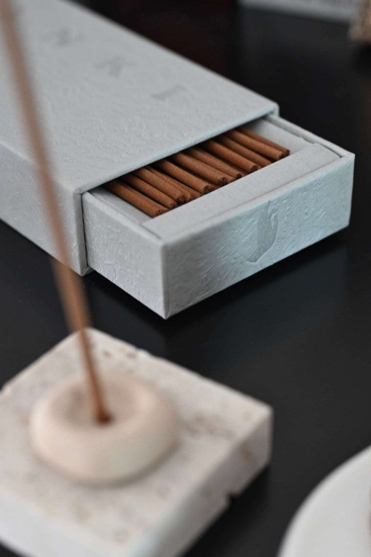 9to5 Studios light gray textured paper incense box with sliding drawer and natural brown sticks in stone holder