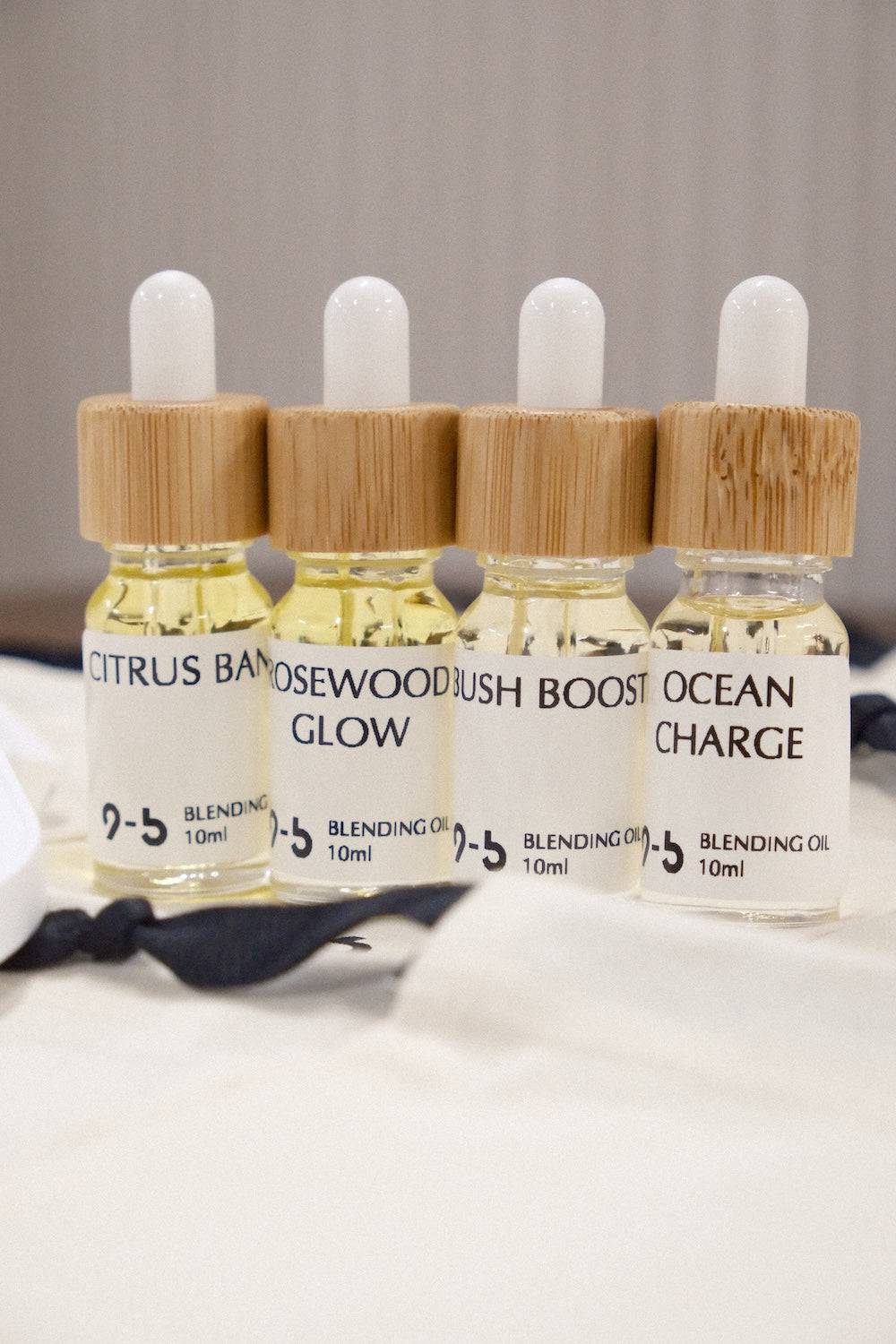 9to5 Studios blending oil collection with bamboo caps and citrus, rosewood, bush, and ocean scents in glass dropper bottles