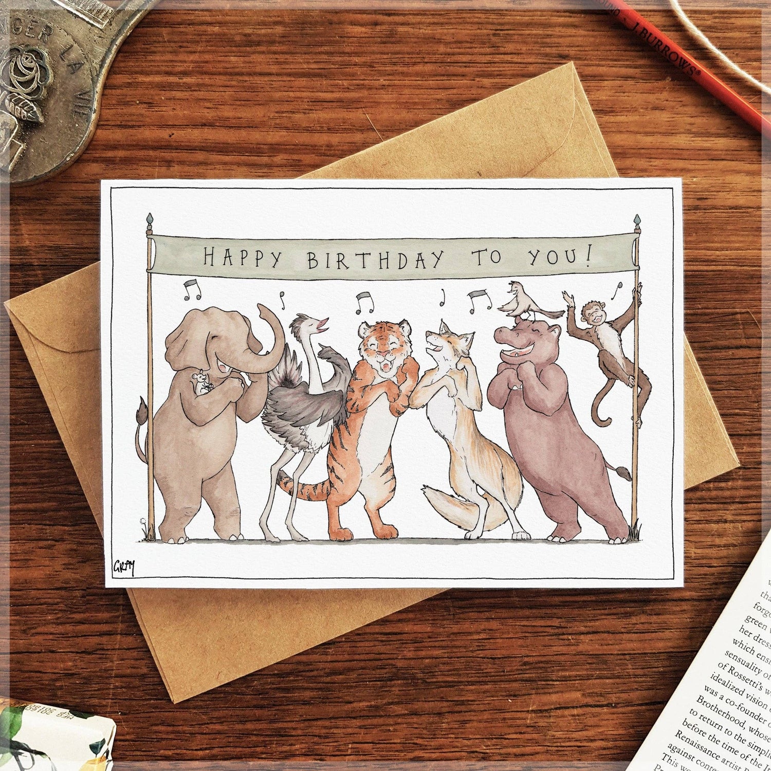9to5 Studios watercolor birthday card with dancing animals on kraft paper envelope