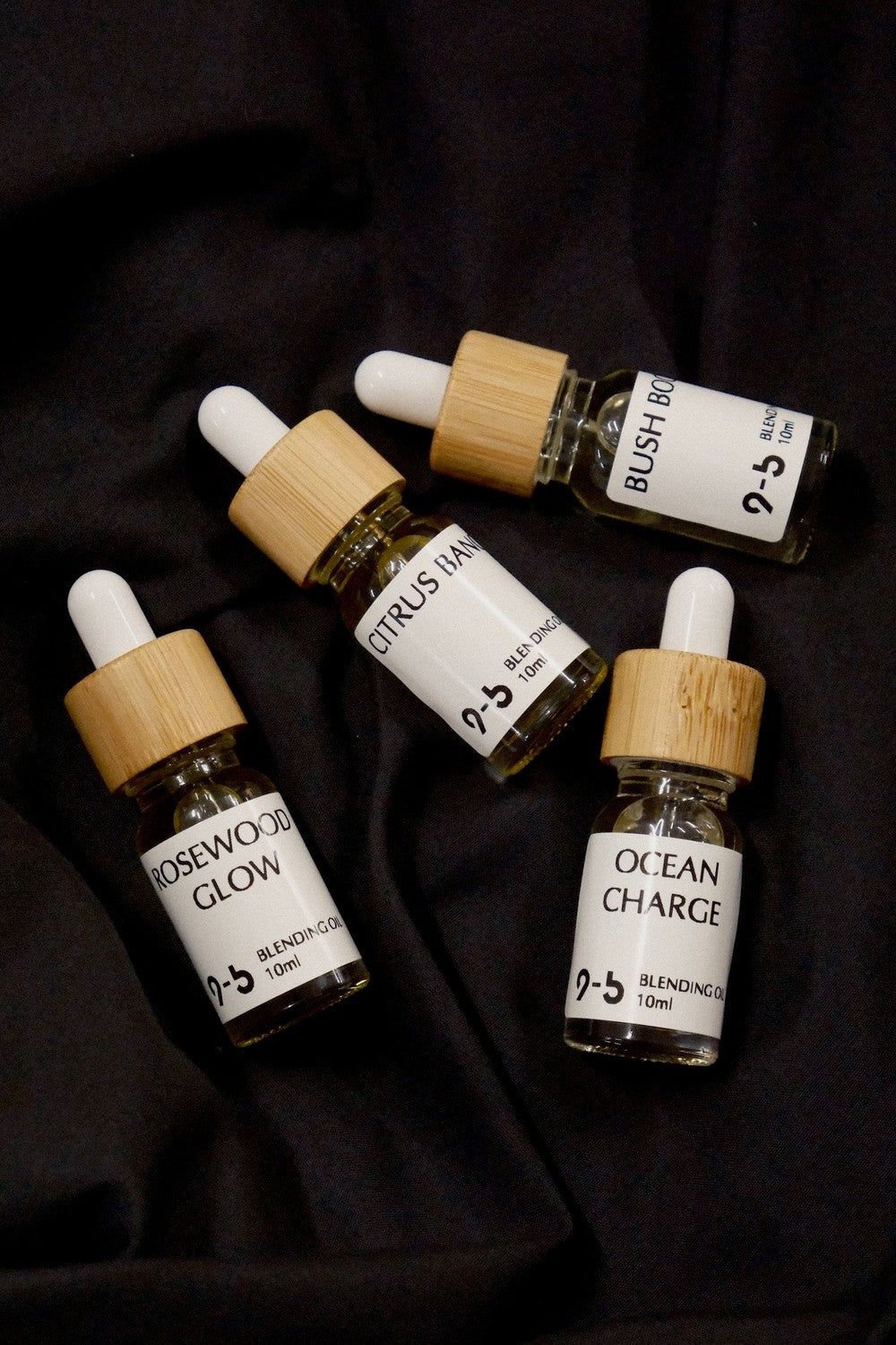 Casual arrangement of 9to5 Studios Blending Oil 10ml bottles showing Rosewood Glow and Citrus Bang