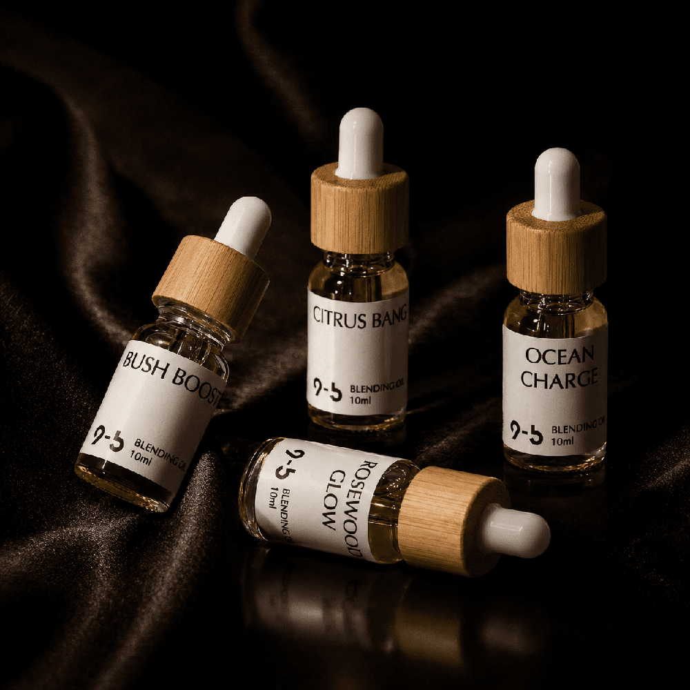 Four 9to5 Scents blending oils including Bush Boost and Citrus Bang on satin fabric
