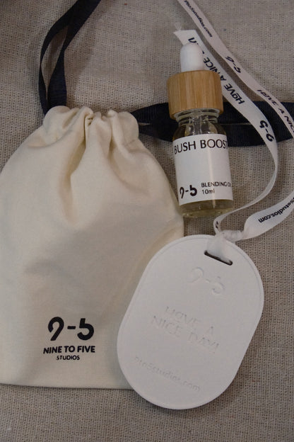 9to5 Studios Bush Boost oil, pouch, and ceramic tag on fabric