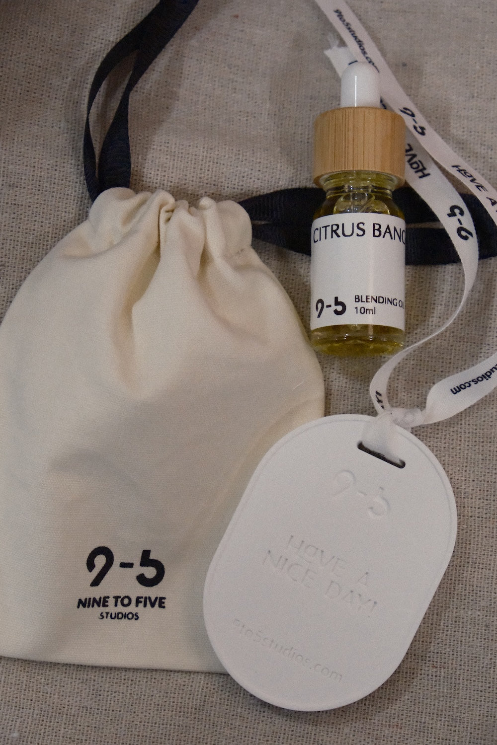 9to5 Studios Citrus Bang oil gift set with pouch on beige textured background