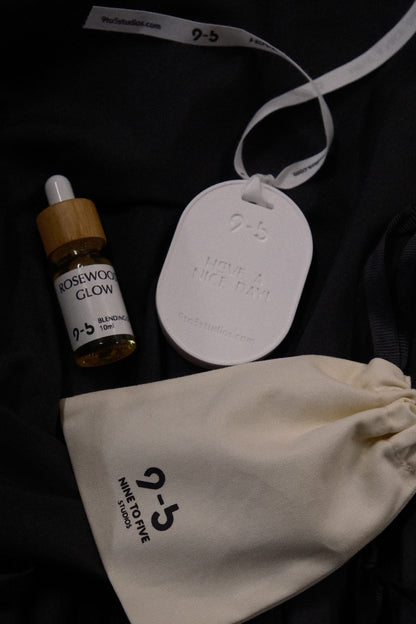 Rosewood Glow oil bottle with 9to5 Studios tag and pouch