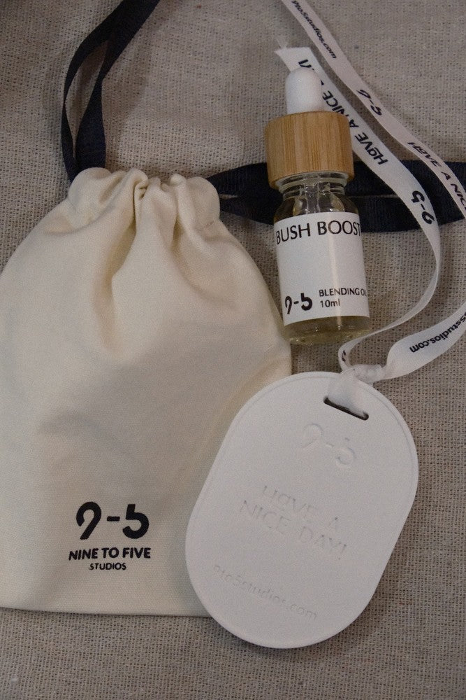 9to5 Studios Bush Boost oil, pouch, and ceramic tag on fabric