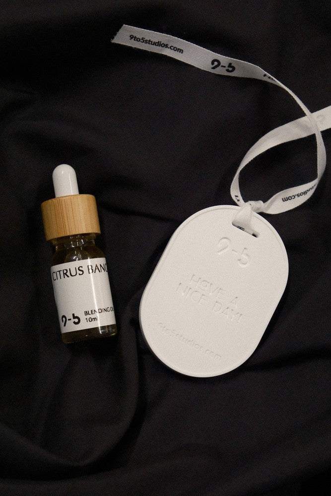 9to5 Studios Citrus Bang oil bottle with ribbon tag and bamboo cap detail
