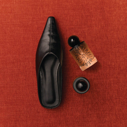Odesse Deep Orchid perfume and black mule shoe flat lay at 9to5 Studios