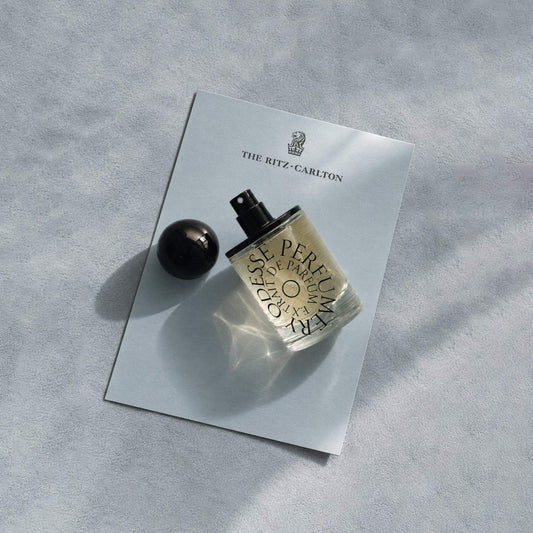 Odesse Hotel Jasmine Extrait De Parfum bottle on Ritz-Carlton branded card with golden-amber liquid visible