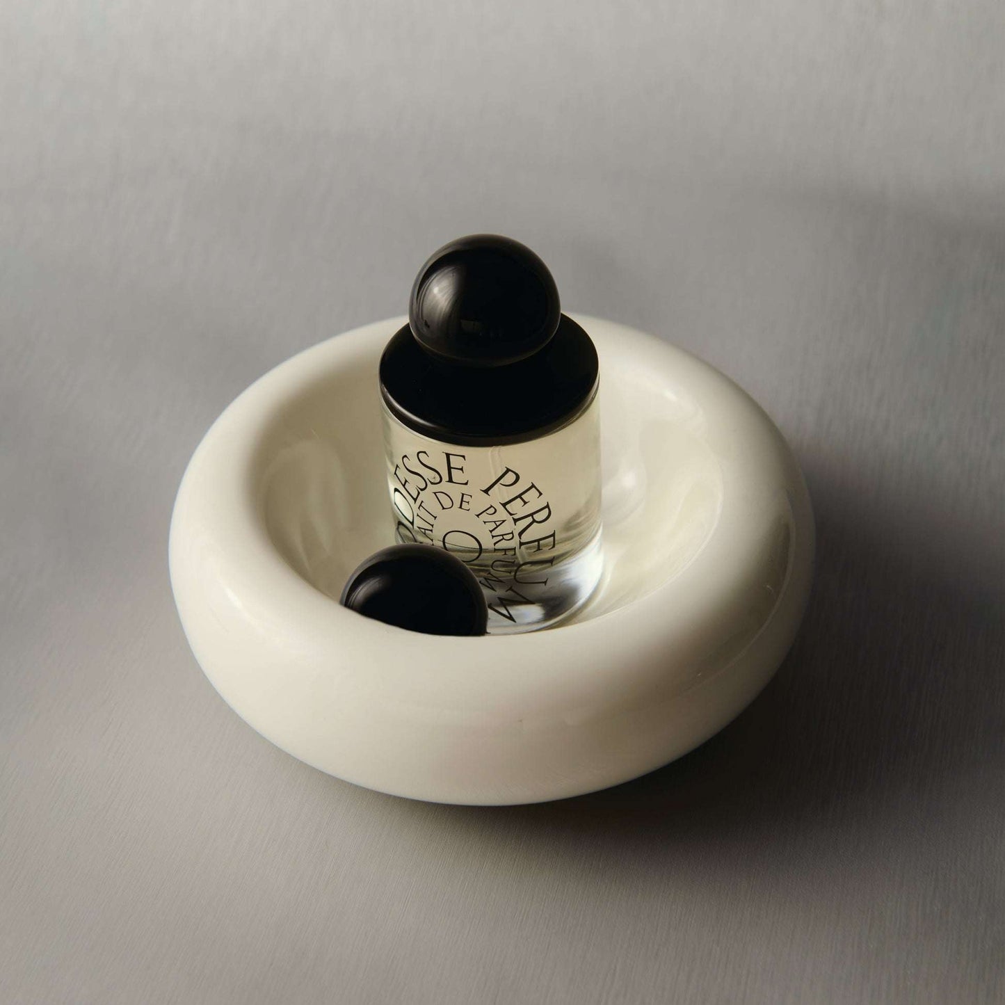Odesse Hotel Jasmine Extrait De Parfum in glass bottle with black cap inside white ceramic bowl at 9to5 Studios