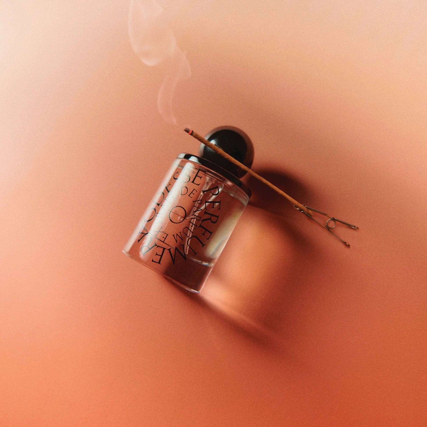 Odesse The Valley perfume bottle with lit incense stick on terracotta surface at 9to5 Studios