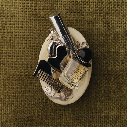 Odesse The Valley perfume flat lay with vintage accessories in ceramic dish at 9to5 Studios