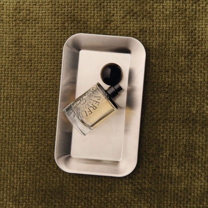 Odesse The Valley perfume bottle on brushed silver tray with olive fabric background at 9to5 Studios