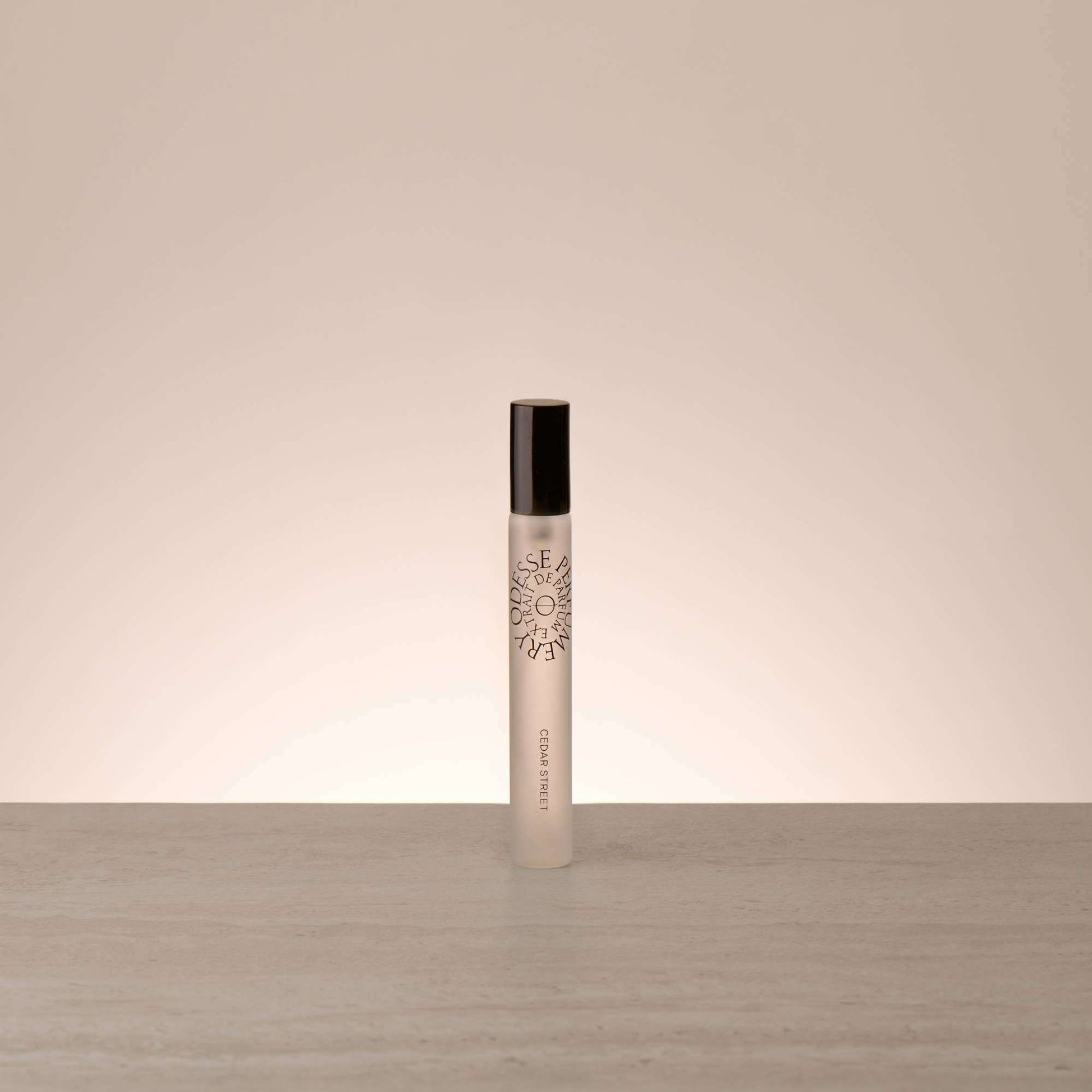 Odesse Travel Size Cedar Street Extrait De Parfum rollerball in frosted glass with matte black cap by 9to5 Studios