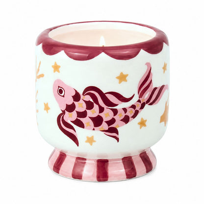Lit Paddywax ceramic Koi candle featuring hand-painted pink maroon fish and gold seaweed