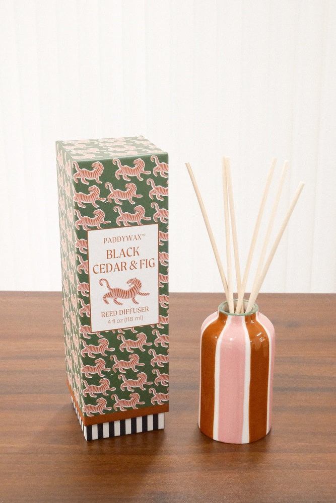 Paddywax A Dopo Tiger Reed Diffuser on wood showing rounded striped ceramic vessel and green packaging
