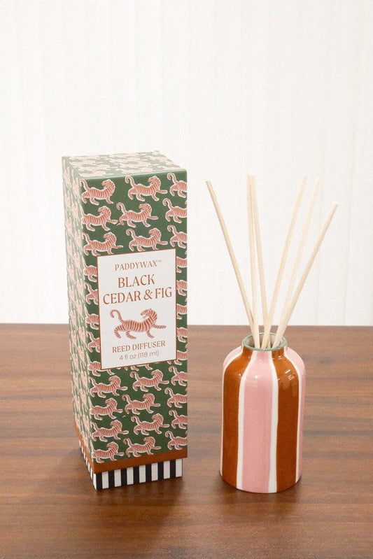 Paddywax A Dopo Tiger Reed Diffuser on wood showing rounded striped ceramic vessel and green packaging