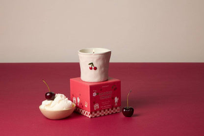 Paddywax Bistro Smoked Cherry ceramic candle with embossed red cherry on pink gift box and whipped cream styling