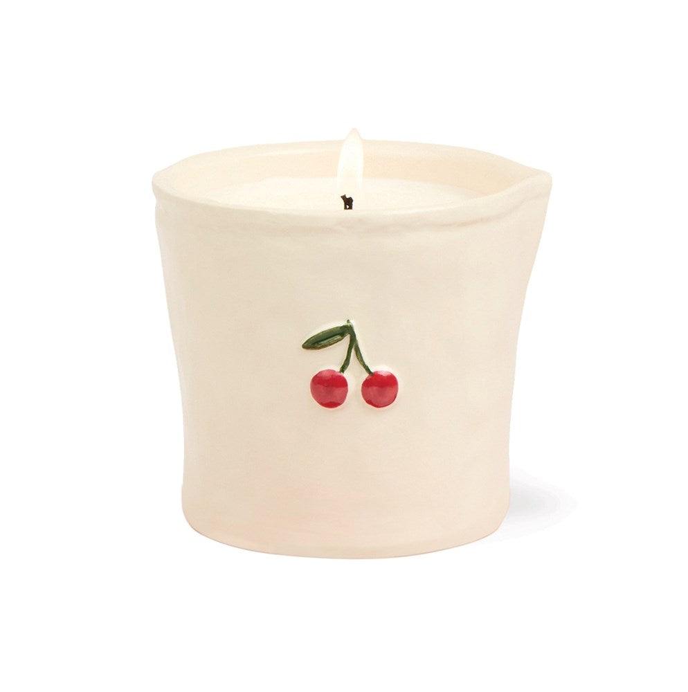 Close-up Paddywax Bistro white ceramic candle showing 3D embossed red cherry detail and soy wax wick