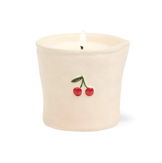 Close-up Paddywax Bistro white ceramic candle showing 3D embossed red cherry detail and soy wax wick