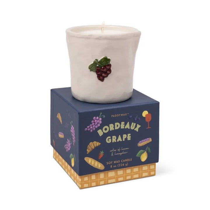 Paddywax Bordeaux Grape embossed ceramic candle in matte off-white with raised burgundy grape cluster on navy blue box