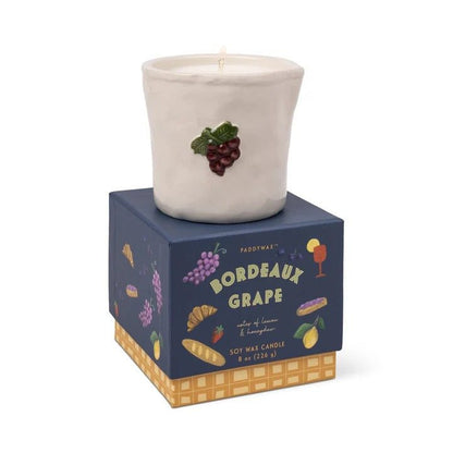 Paddywax Bordeaux Grape embossed ceramic candle in matte off-white with raised burgundy grape cluster on navy blue box