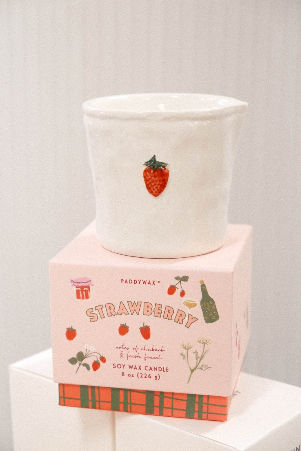 Close-up of Paddywax Strawberry soy wax candle showing textured ceramic surface and label