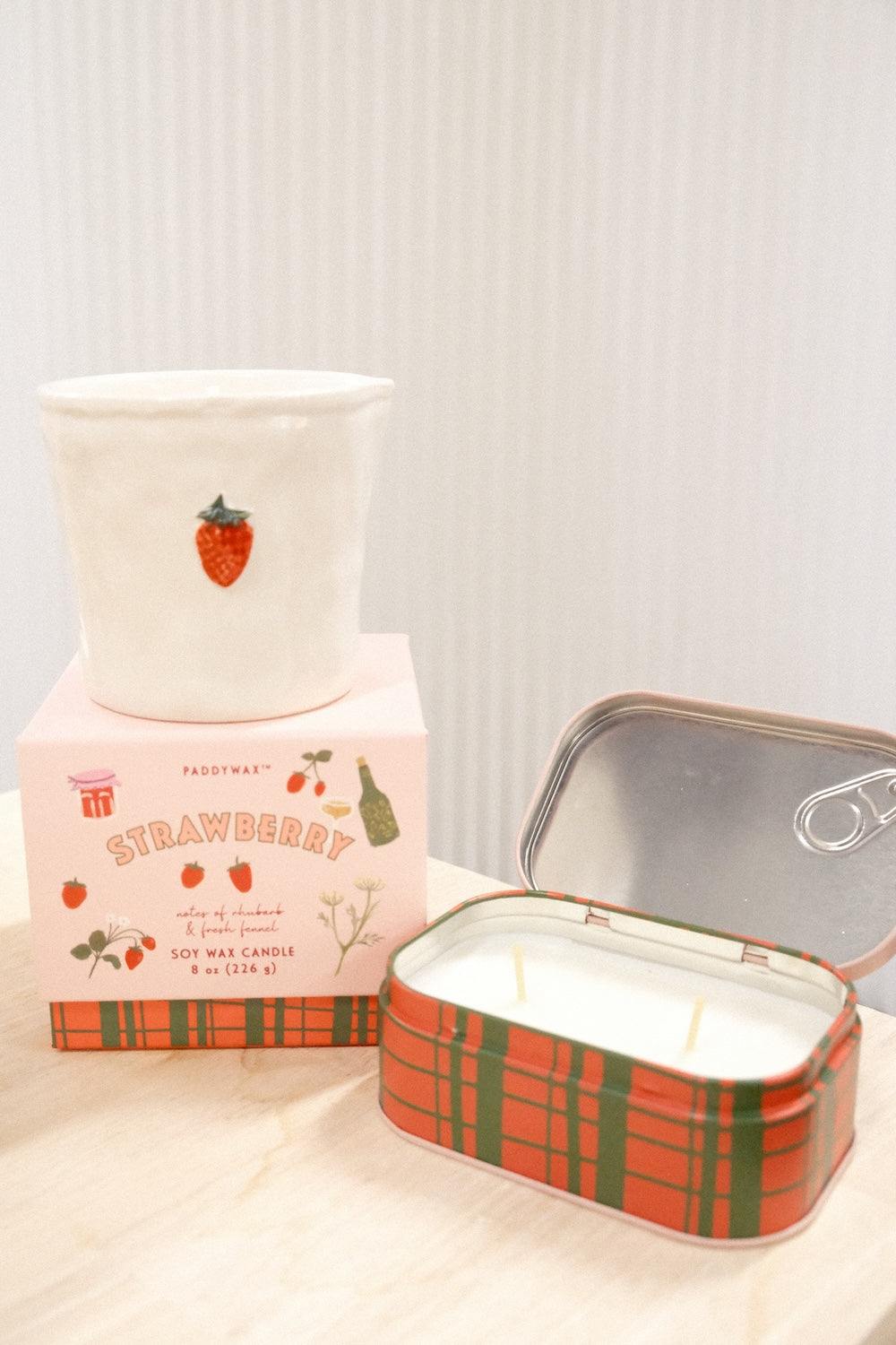 Paddywax Strawberry candle display with open plaid tin, unlit wicks, and matching gift box packaging