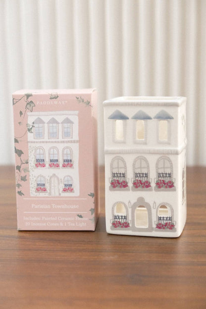 Front view of Paddywax white ceramic Parisian townhouse incense holder featuring arched windows, black iron railings, and included incense cones