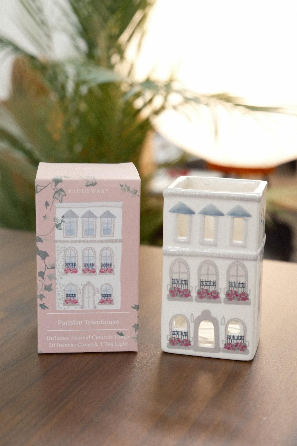 Paddywax white matte ceramic Parisian townhouse incense holder with pink flower boxes and blue-gray dormers beside original packaging