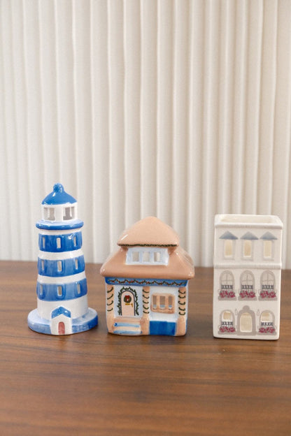 Set of three Paddywax ceramic decorative holders including lighthouse and multi-story building designs