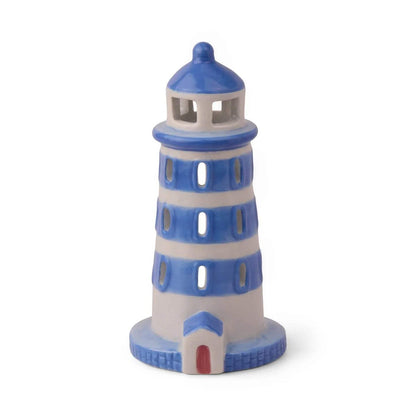 Side view of PADDYWAX cobalt blue and white painted ceramic lighthouse with brick-textured base and circular windows