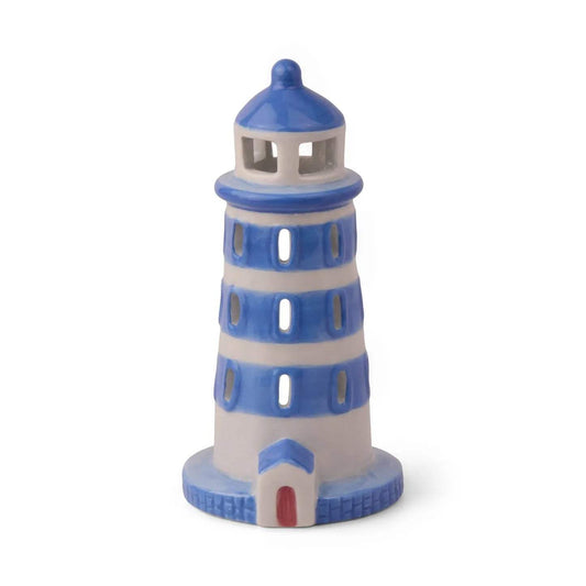Side view of PADDYWAX cobalt blue and white painted ceramic lighthouse with brick-textured base and circular windows