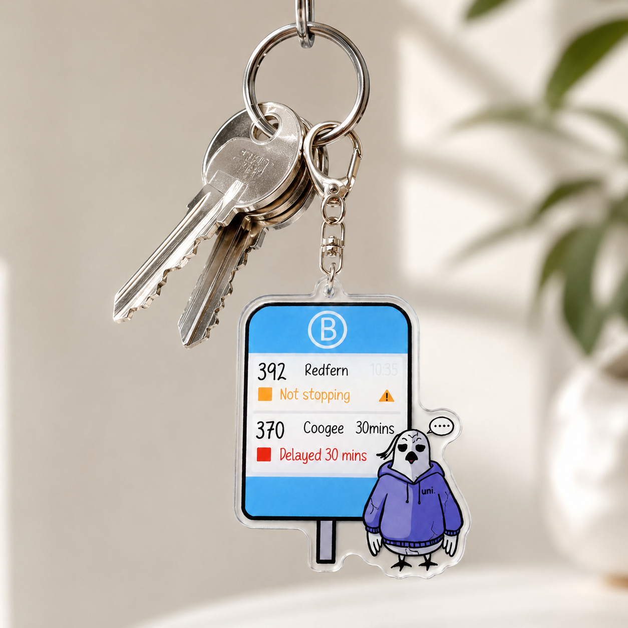 +61 Studio Not Stopping Keychain with cockatoo and bus stop sign design