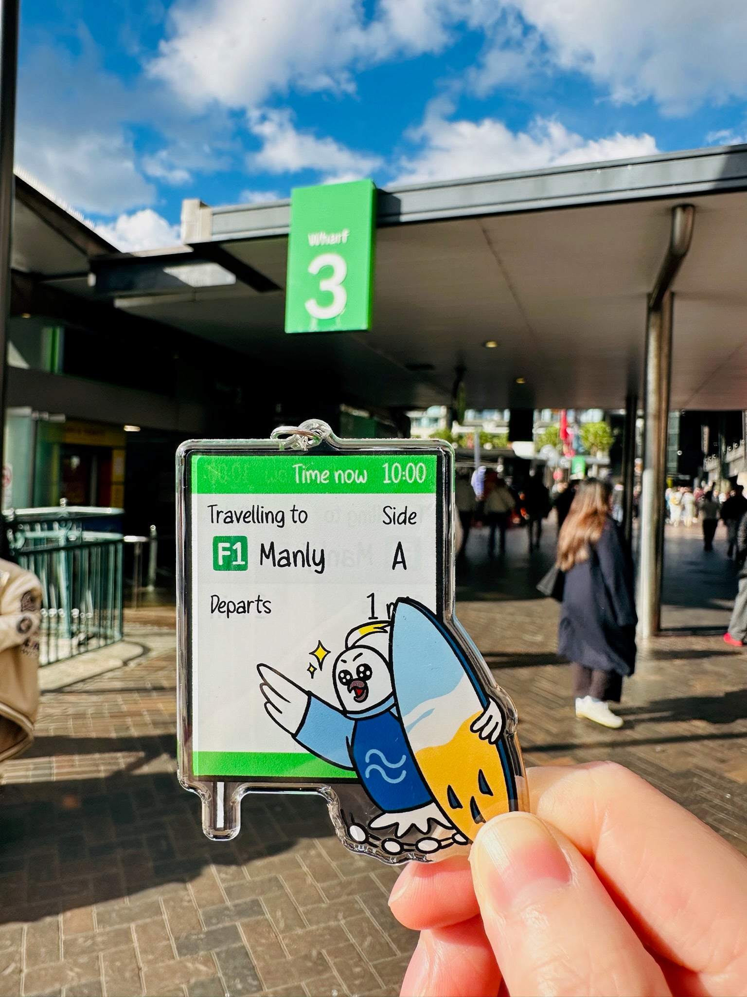 9to5 Studios +61 Studio cockatoo keychain against real Sydney ferry wharf backdrop