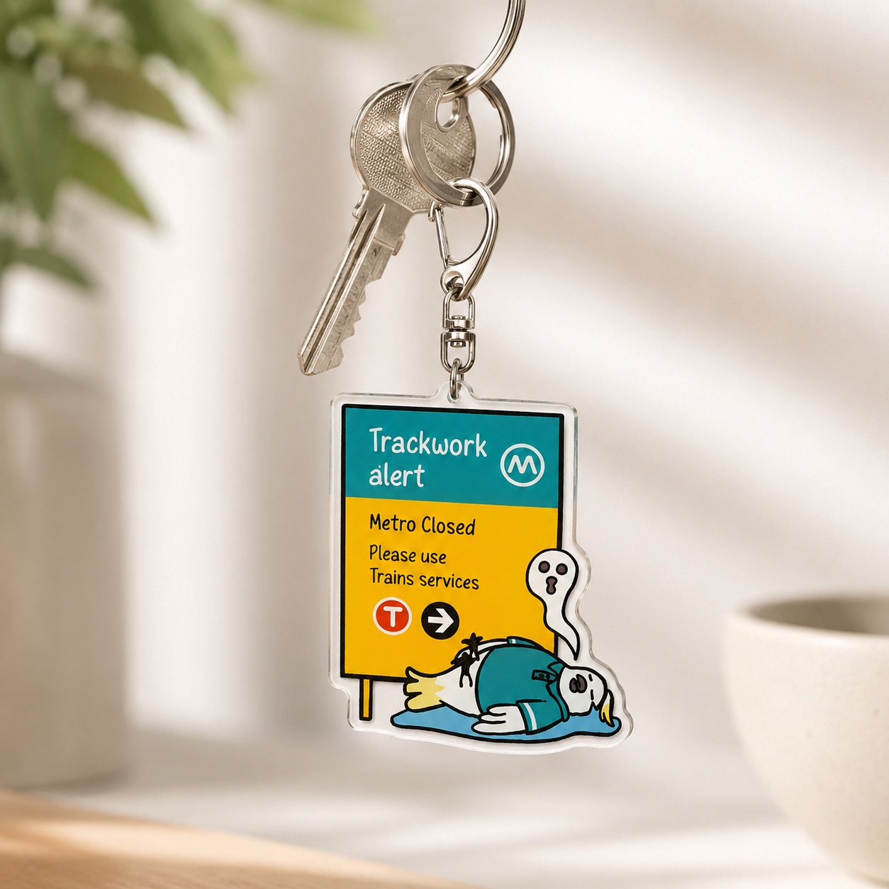 +61 Studio Trackwork Alert keychain hanging on keys with cartoon character detail