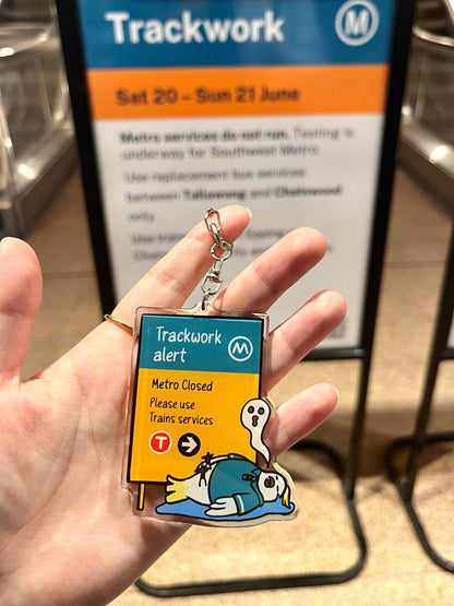 Close-up +61 Studio Trackwork Alert Keychain clear acrylic teal orange transit sign silver clasp 9to5 Studios