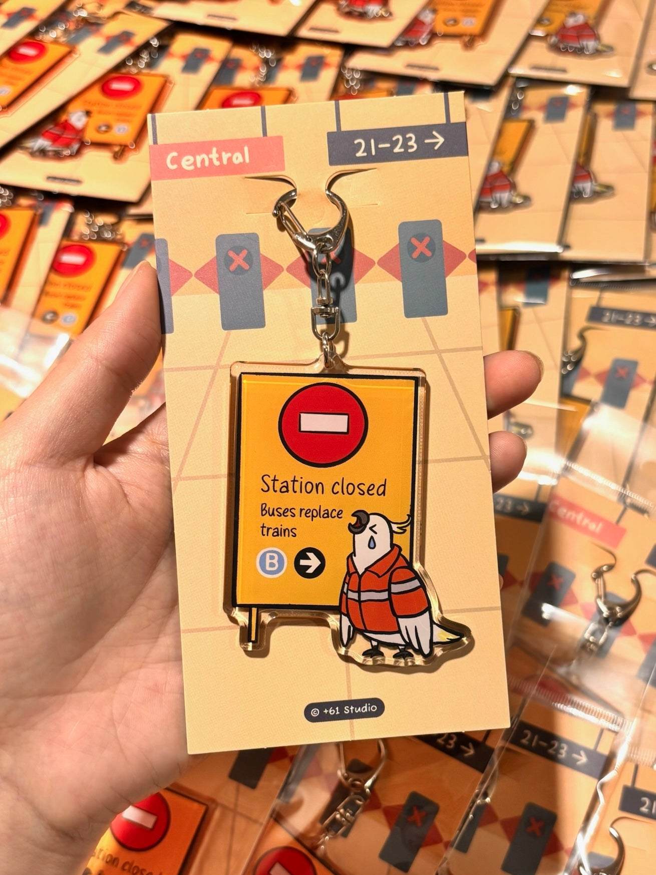 +61 Studio Train Station Closed keychain featuring teary-eyed cockatoo and metal clasp on premium acrylic