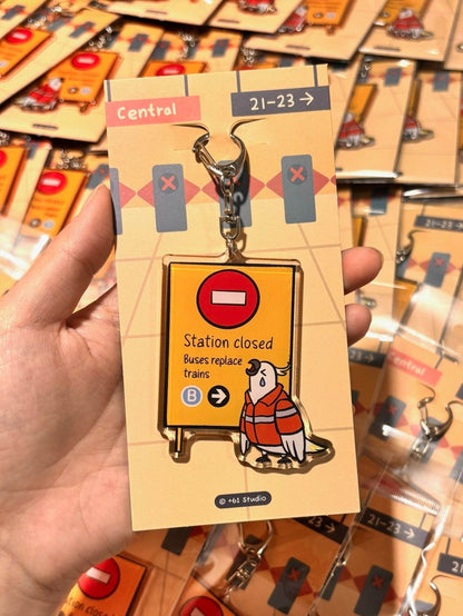 +61 Studio Train Station Closed keychain featuring teary-eyed cockatoo and metal clasp on premium acrylic