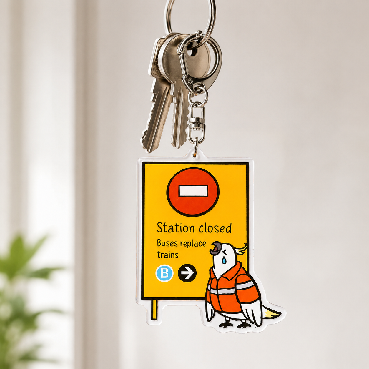 Teary-eyed cockatoo acrylic keychain hanging on keys by +61 Studio