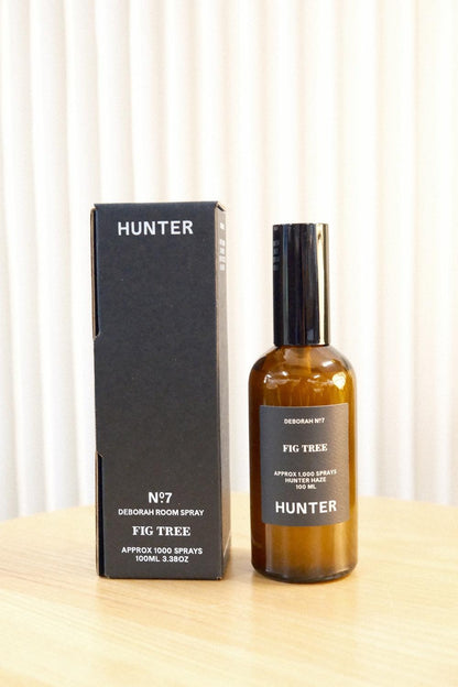 Hunter Candles Deborah fig tree room spray bottle next to black box against curtain