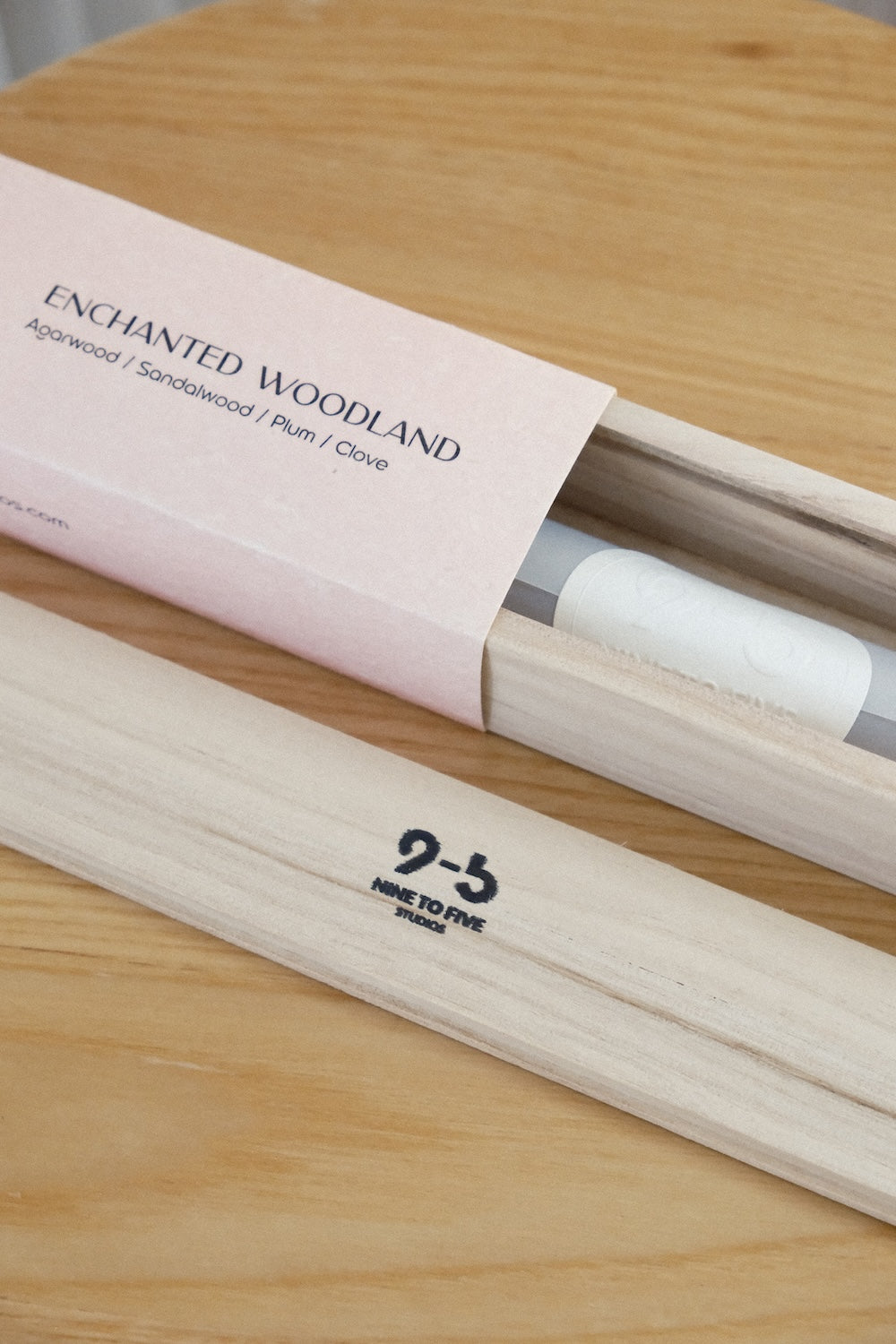 Close-up of Enchanted Woodland incense box sliding over natural wood holder