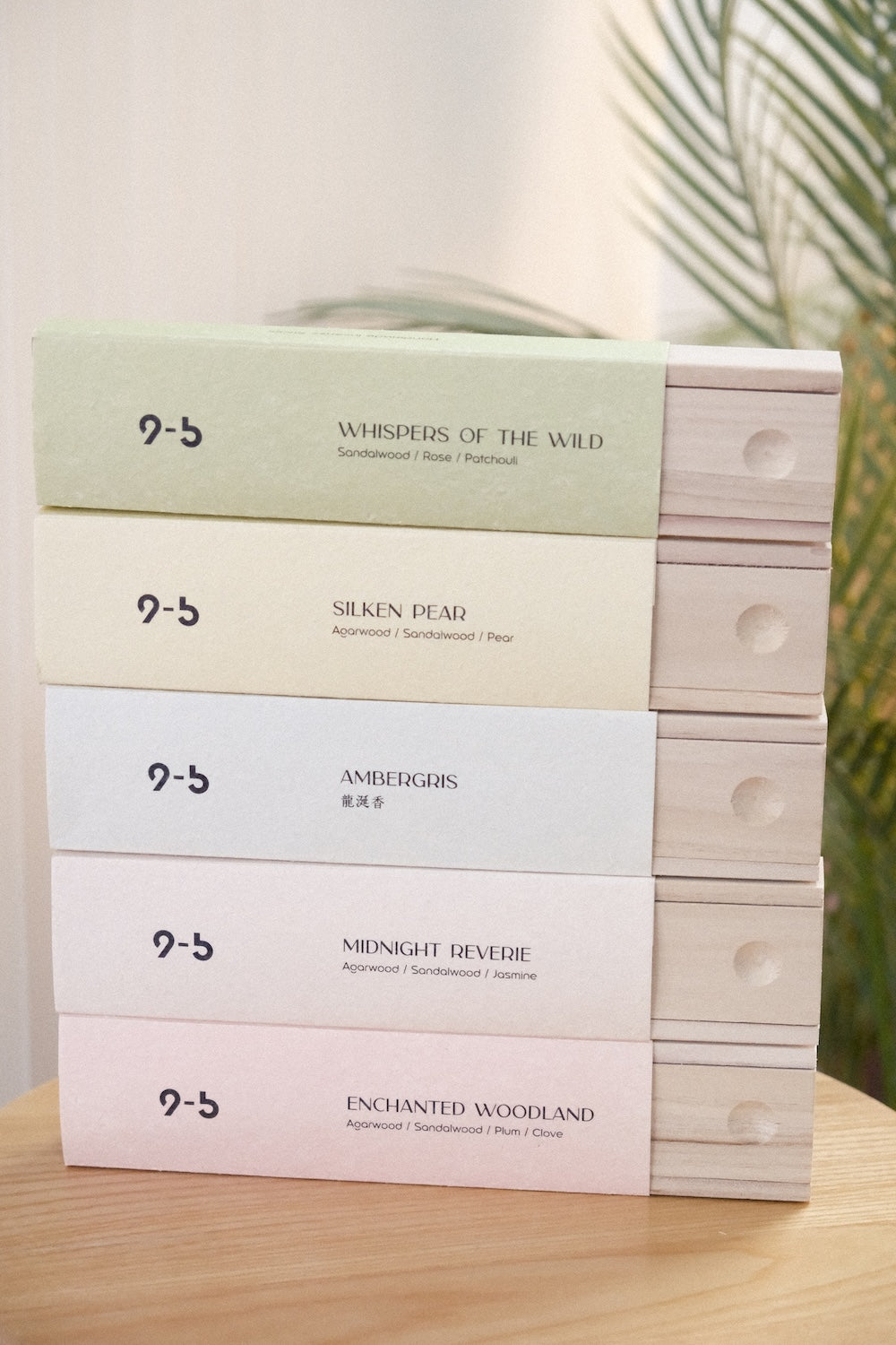 Vertical stack of five pastel incense boxes with visible wooden drawer sides